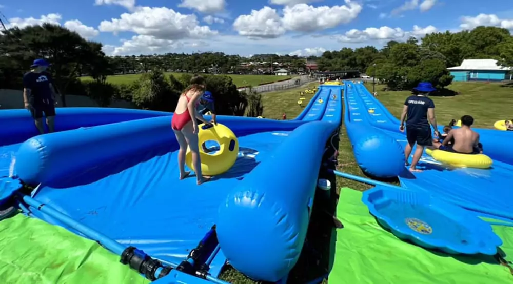 Commercial-slip-n-slide-setup-on-a-grassy-slope