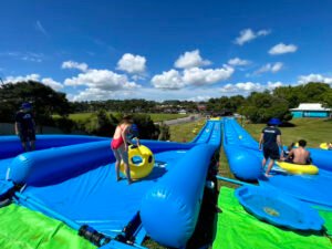 Commercial-slip-n-slide-setup-on-a-grassy-slope