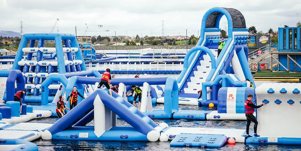 Visitors enjoying attractions at a commercial inflatable water park