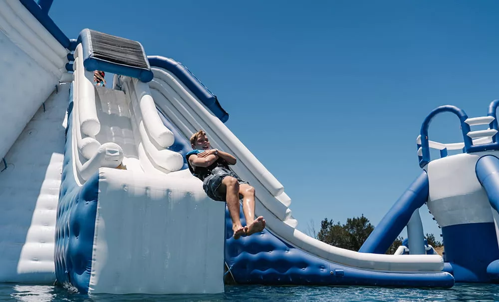 Visitors enjoying a thrilling attraction at an inflatable water park