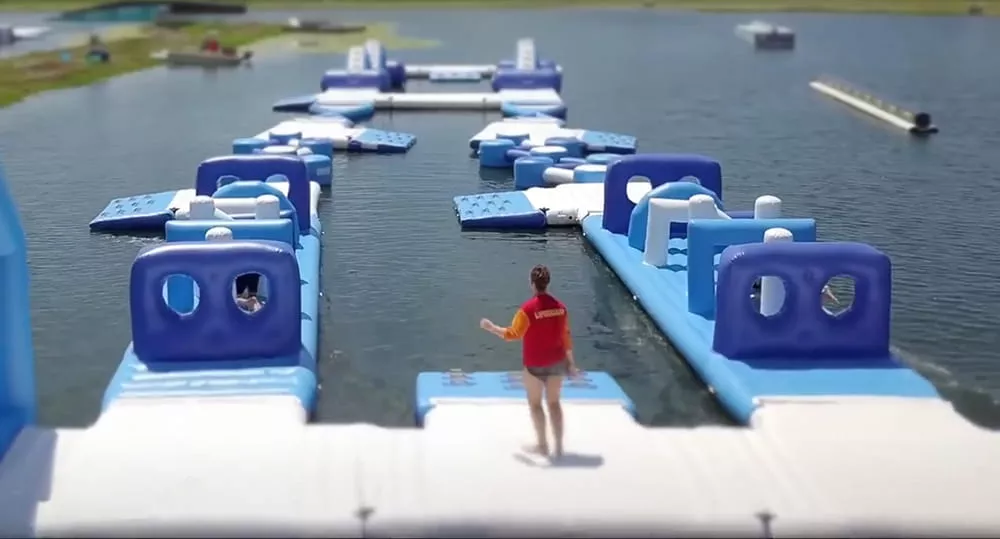staff-overseeing-floating-inflatable-obstacle-course-racing-lanes