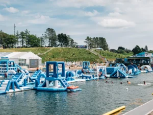 Parc aquatique gonflable en activité avec des visiteurs et du personnel