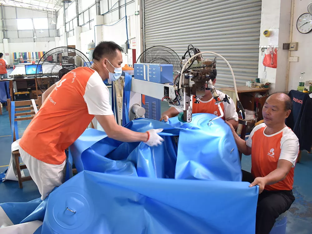 workers-welding-floating-obstacle-course-material-during-factory-production
