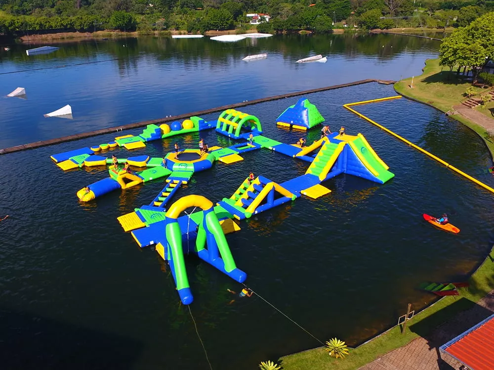 Circuito acuático hinchable en un entorno soleado junto a un lago