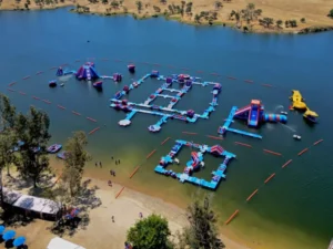 Parcours aquatique gonflable avec des visiteurs près de la rive d’un lac